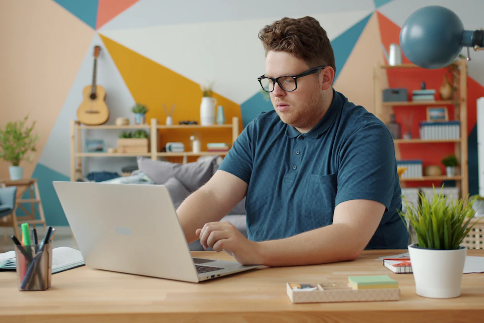 Freelancer concentrado em notebook no ambiente de trabalho em casa